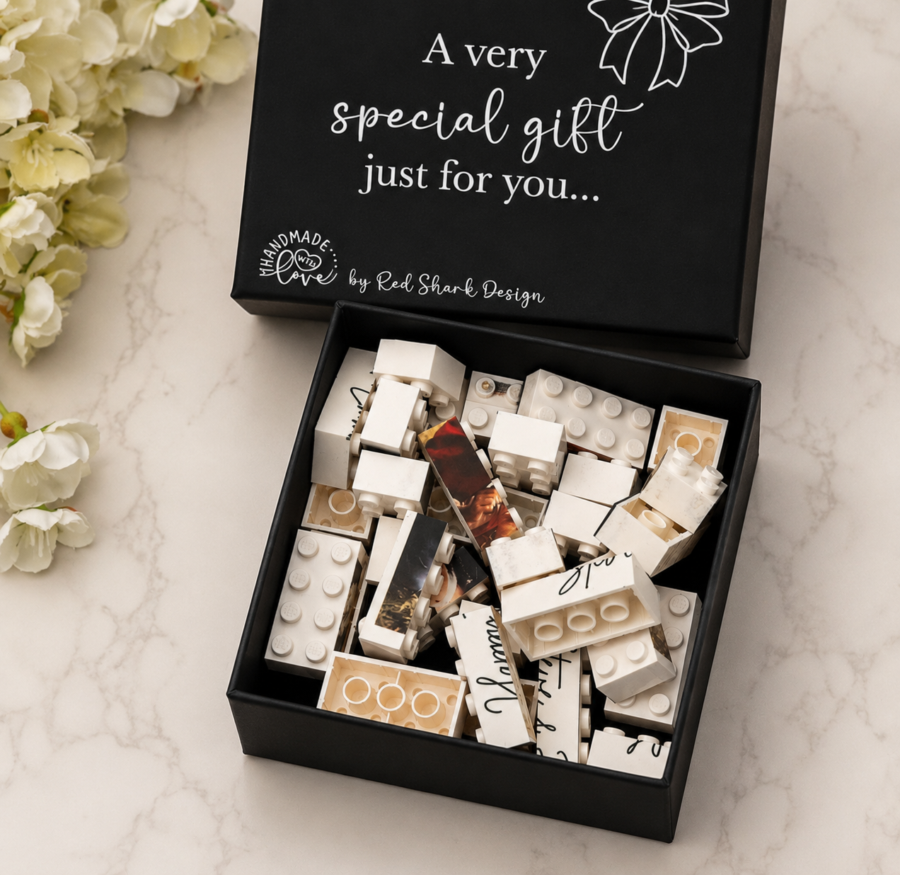 Box of personalized lego bricks with a decorative message on a marble surface