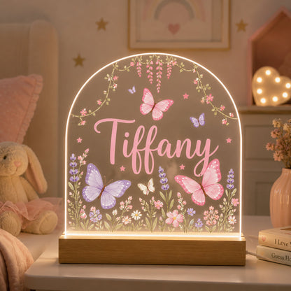 Decorative lamp with 'Tiffany' and floral designs on a shelf with a soft, warm background.