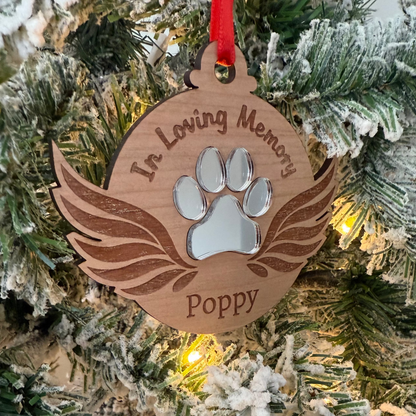Ornament with paw print and 'In Loving Memory Poppy' text on a Christmas tree.
