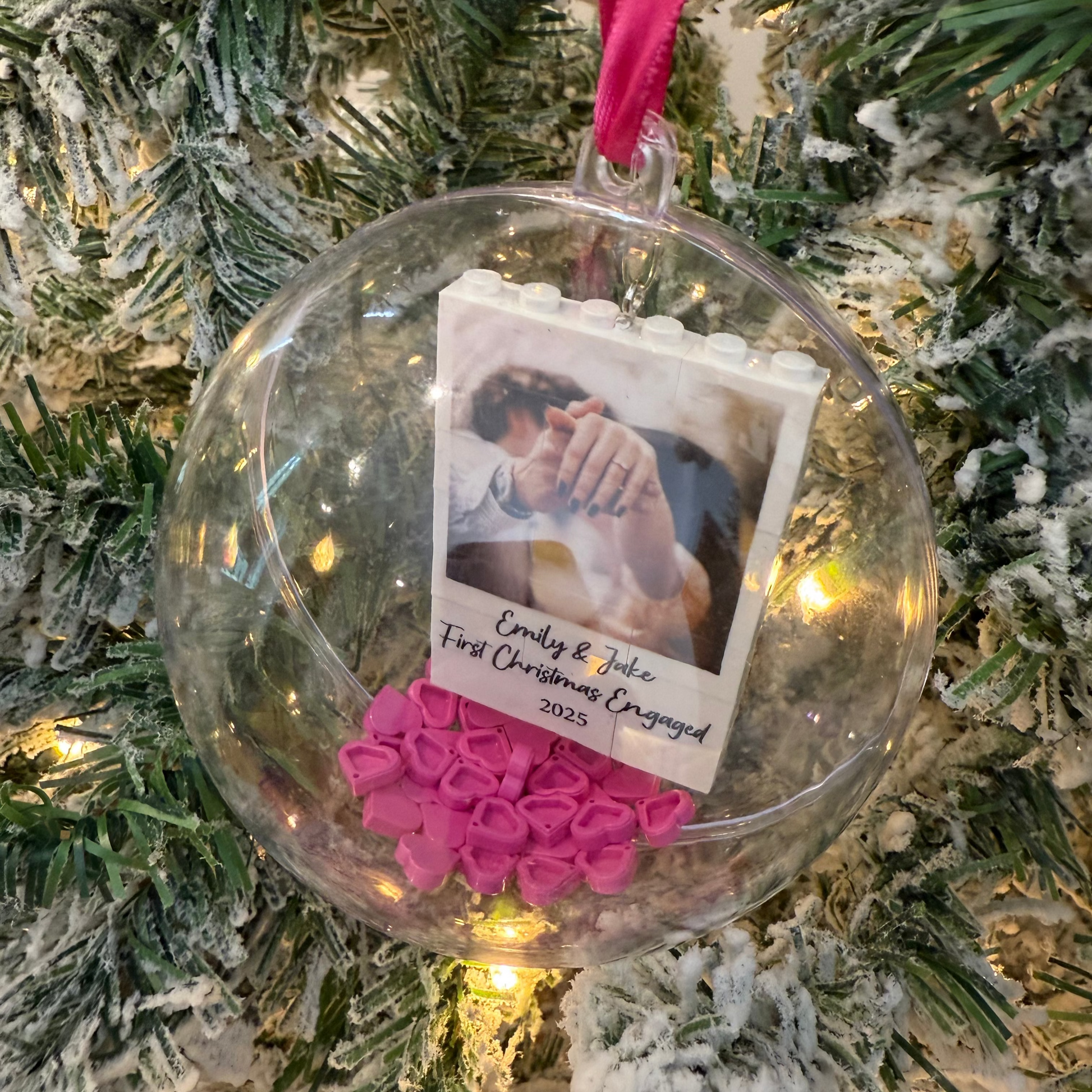 Christmas ornament with a photo and pink hearts on a decorated tree
