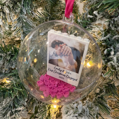 Christmas ornament with a photo and pink hearts on a decorated tree