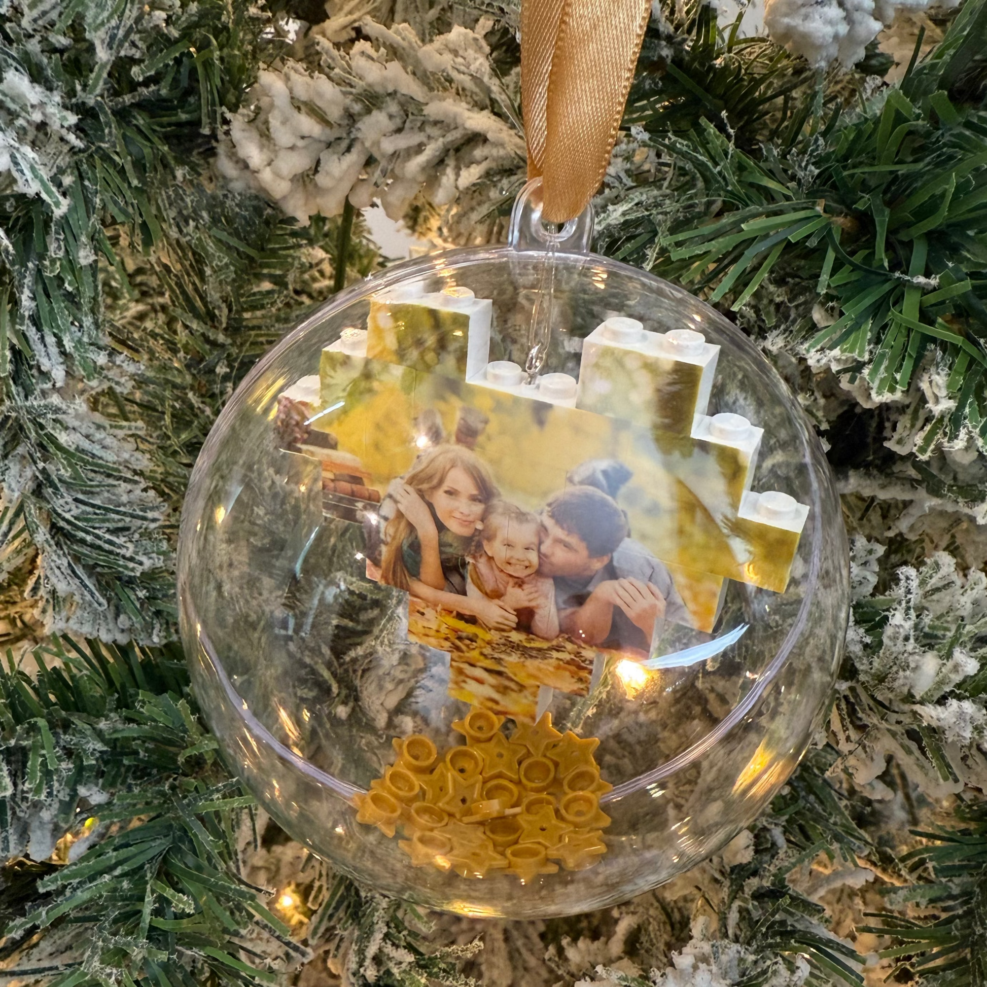 Decorative acrylic ornament with a photo inside, hanging on a Christmas tree.